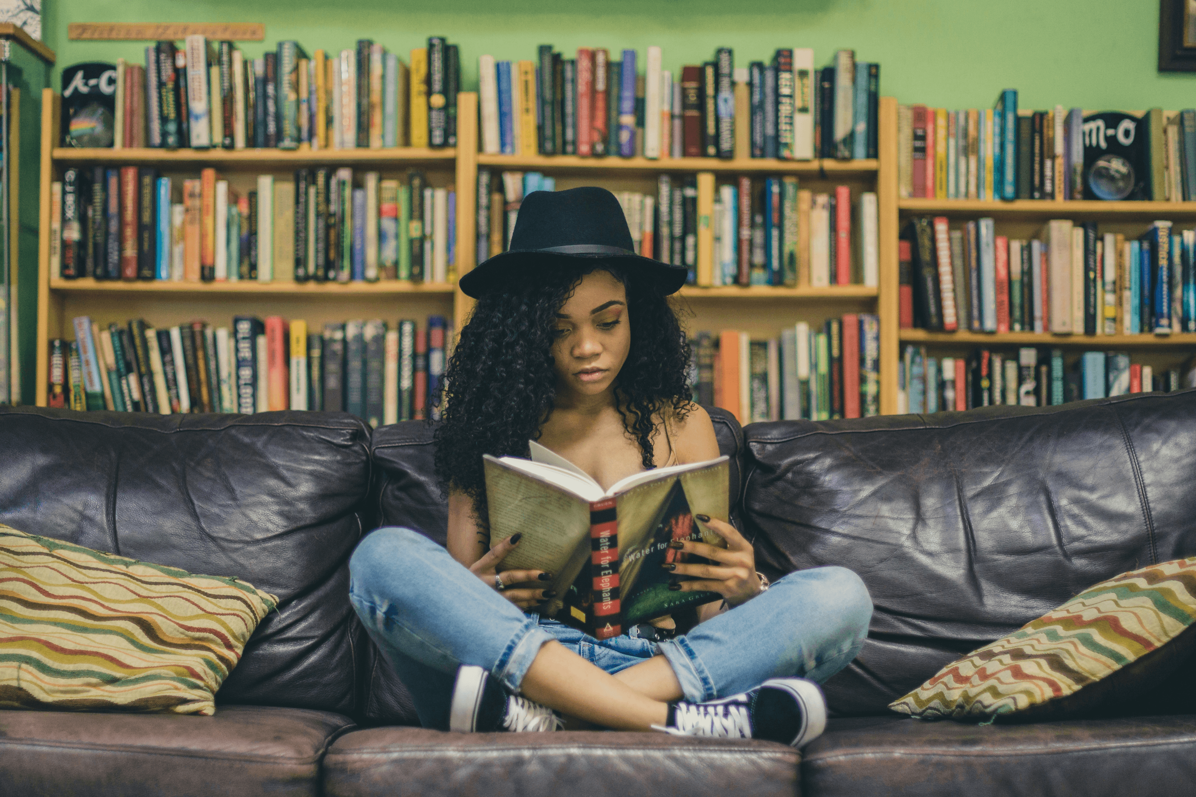 Woman reading with bookshelves